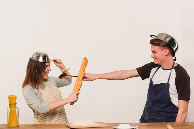 Foto grátis par jovem, enganando ao redor, enquanto, cozinhar, em, cozinha
