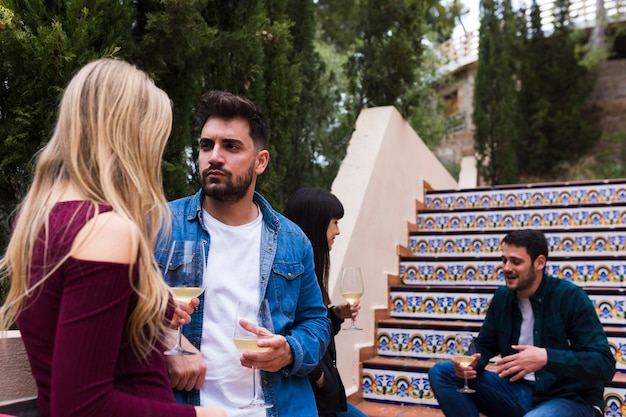 Foto grátis par jovem, ficar, perto, escadaria, com, vidro vinho