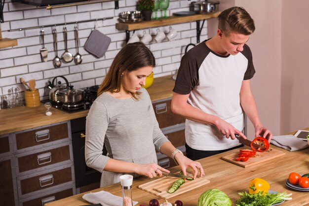 Par jovem, legumes cortantes, em, cozinha