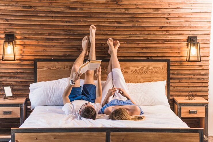 Foto grátis par, mentindo, ligado, cozy, cama, com, seu, pernas cima, ligado, a, parede