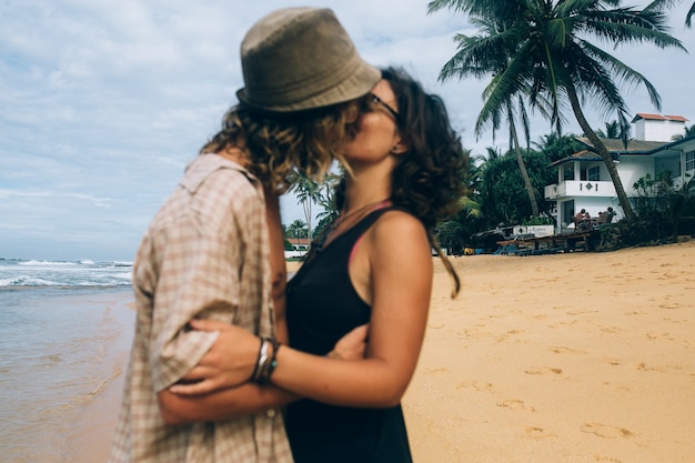 Par romântico dando um beijo apaixonado na praia