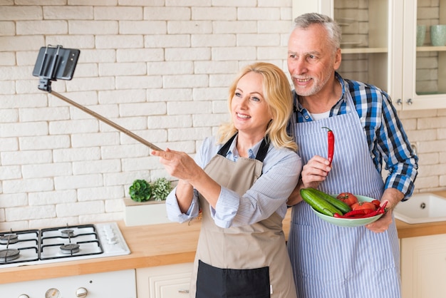 Foto grátis par velho, levando, selfie, ligado, telefone móvel, cozinha