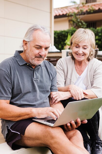 Par velho, usando computador portátil, em, jardim