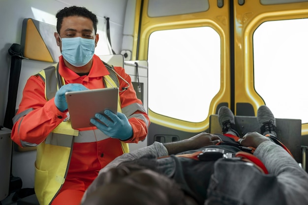 Foto grátis paramédico de tiro médio segurando o tablet