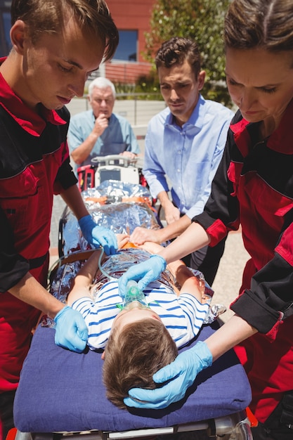 Foto grátis paramédicos examinando menino ferido