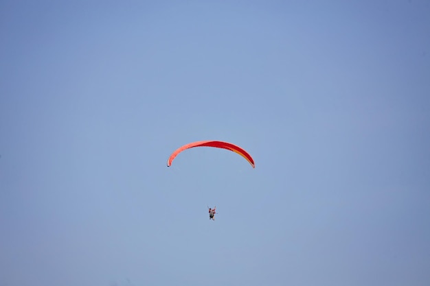 Parapente no céu Parapente voando em dia ensolarado Belo parapente em voo em um fundo turquesa