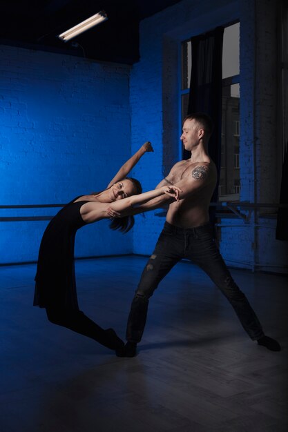 Foto grátis parceiros de dança que praticam no estúdio escuro