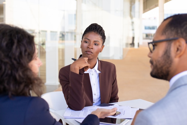 Parceiros de negócios multiétnicas discutindo termos do contrato