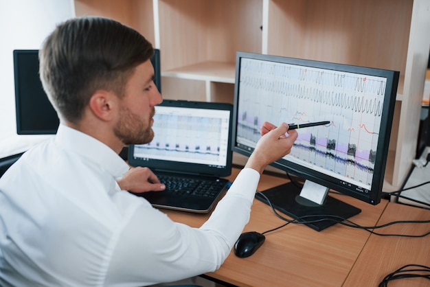 Foto grátis parece muito ruim. o examinador de polígrafo trabalha no escritório com seu equipamento detector de mentiras