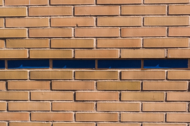 Parede de tijolos com tijolos azuis no meio