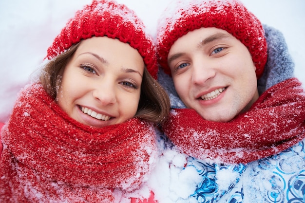 Pares com chapéu de lã vermelho na neve