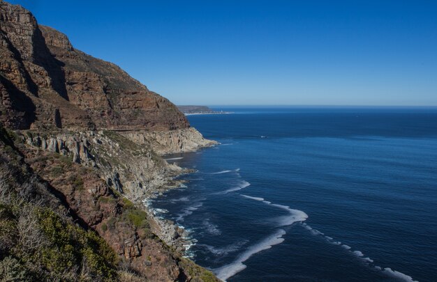 Parque Nacional da Table Mountain cercado pelo mar sob a luz do sol durante o dia na África do Sul
