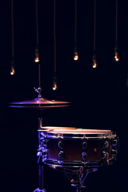 Parte de uma bateria no escuro com bela iluminação. Conceito de concerto e performance.