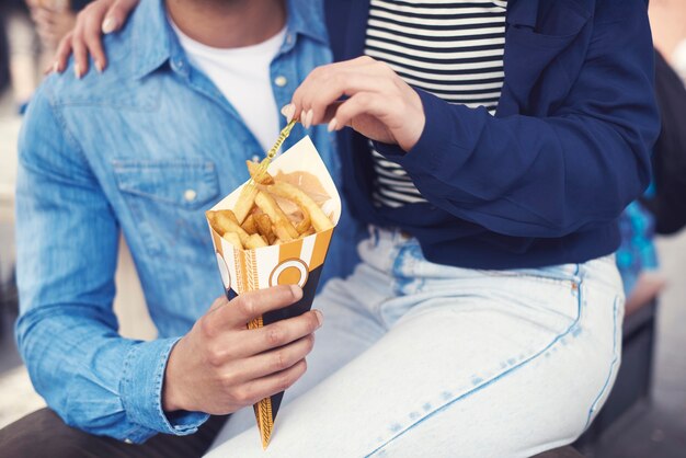 Parte inferior do casal comendo batatas preparadas