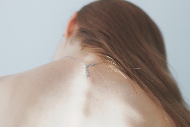Parte superior das costas da mulher com um colar de estrelas