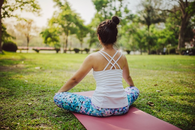 Foto grátis parte traseira da mulher sentada e meditando