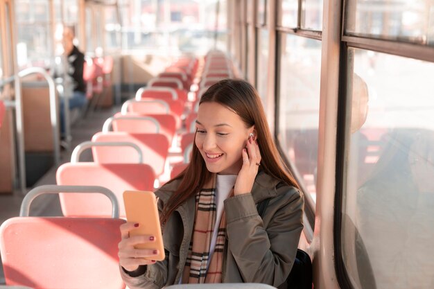 Passageira usando seu telefone celular em transporte público