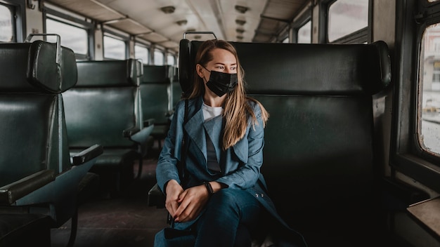 Passageiro no trem sentado e usando máscara médica