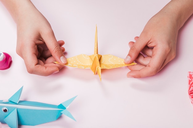 Pássaro feito à mão fêmea do papel do origami no contexto cor-de-rosa
