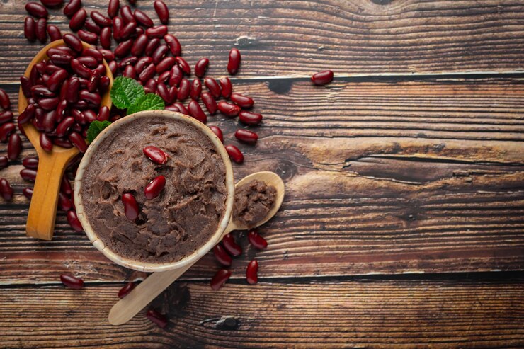 Foto grátis pasta doce de feijão vermelho em tigela branca, coloque no chão de madeira