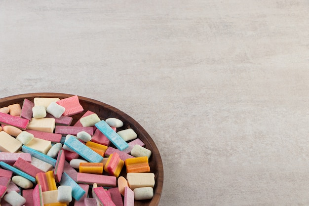 Pastilhas elásticas coloridas colocadas sobre uma mesa de pedra.