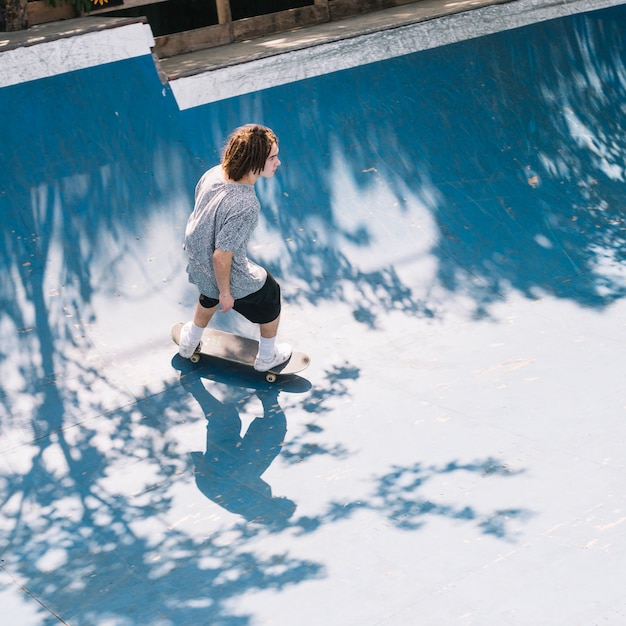 Patinador a bordo montando na rampa