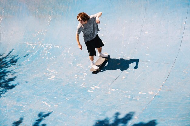 Patinador com dreadlocks na rampa