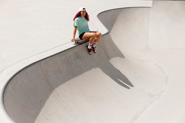 Patinadora de tiro longo com prancha no parque