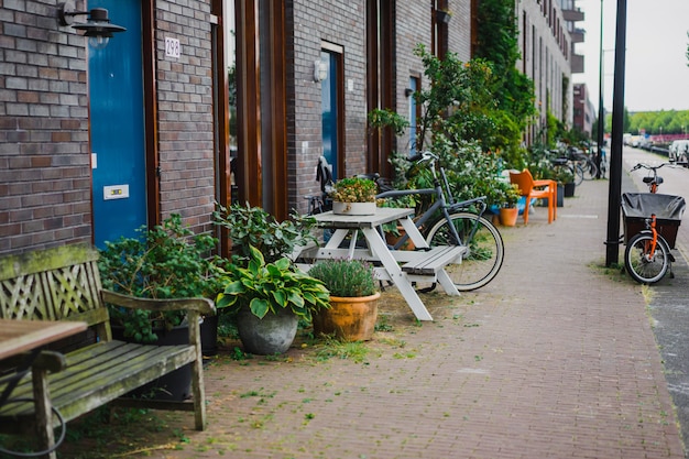 pátios aconchegantes de Amsterdã, bancos, bicicletas, flores em banheiras.