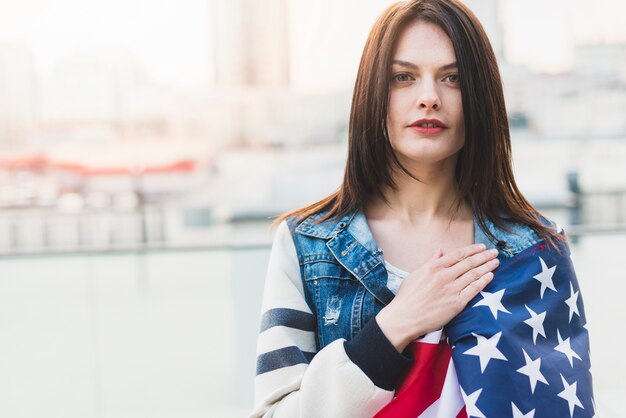 Patriota feminina americana, segurando a mão no coração