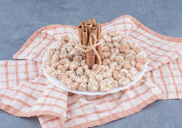 Paus de canela e biscoitos na toalha, no fundo de mármore.