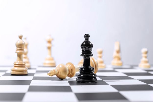 Peça de xadrez de madeira rei derrotada por peça de xadrez bispo preto Foto Premium