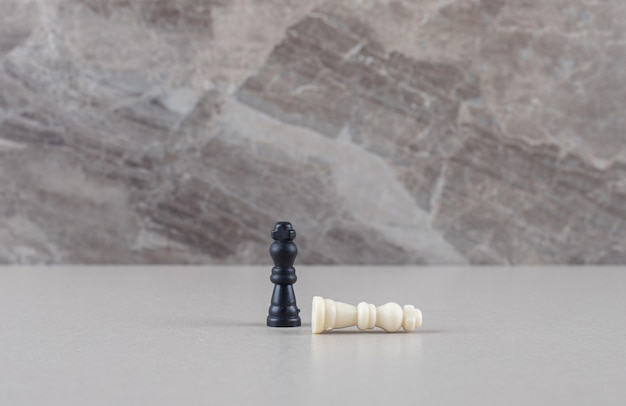Peças brancas e pretas do rei do xadrez em mármore