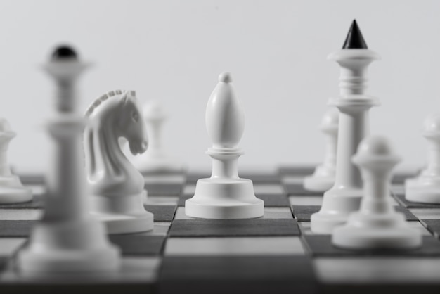 Peças de xadrez monocromáticas com tabuleiro de jogo