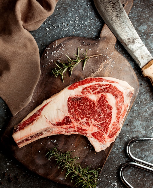 Foto grátis pedaço de bife fresco com faca na mesa