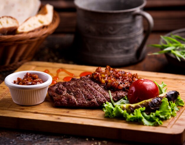 Pedaço de bife frito com cebola frita na mesa