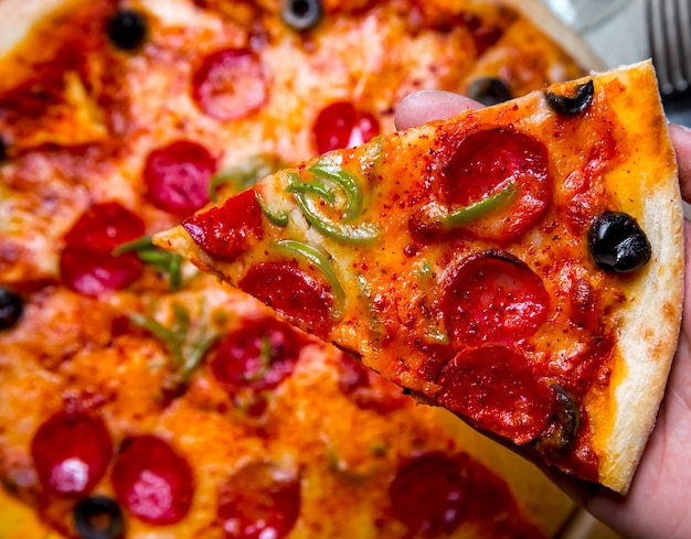 Pedaço de salame pizza azeitonas queijo pimenta vista superior