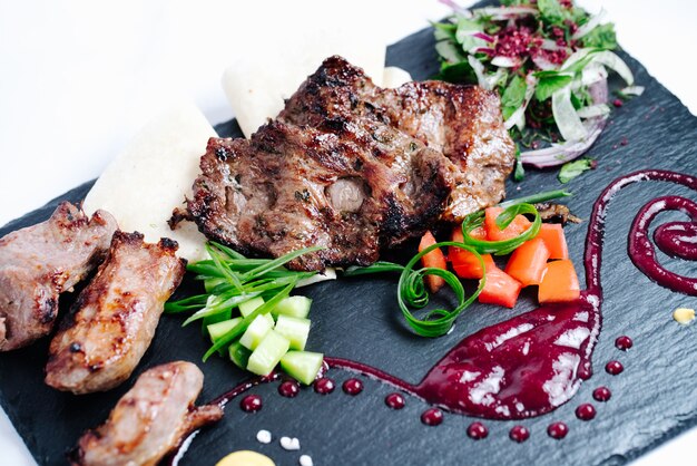 Pedaços de carne frita cebola e outros legumes fatiados