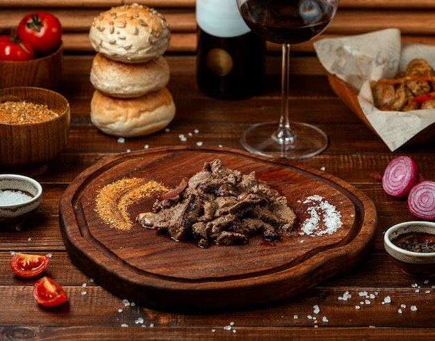 Pedaços de carne frita na placa de madeira