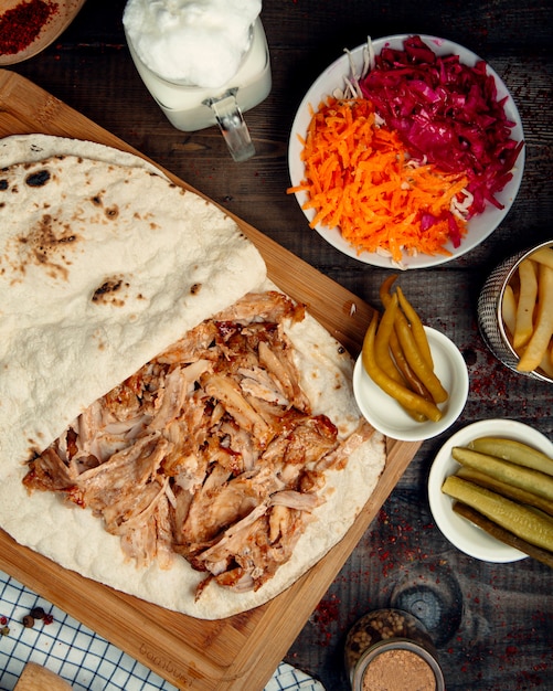 Pedaços de frango picados em pão pita e picles