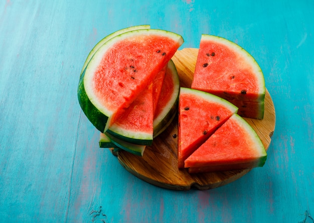 Pedaços de melancia deliciosa sobre fundo azul, plana leigos.