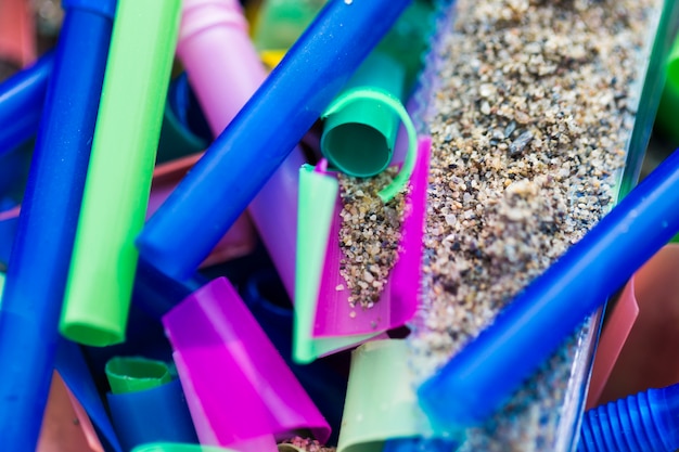 Pedaços plásticos de close-up coletados da areia