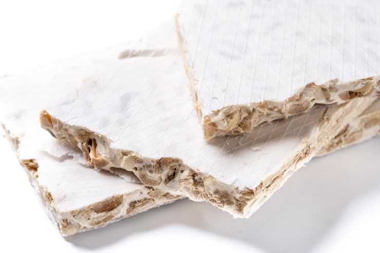 Foto grátis pedaços tradicionais de doces de natal de delicioso nougat de amêndoa isolados sobre fundo branco