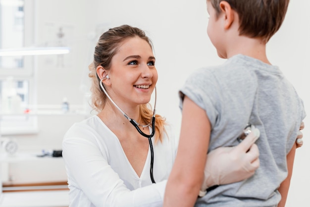 Foto grátis pediatra examinando criança