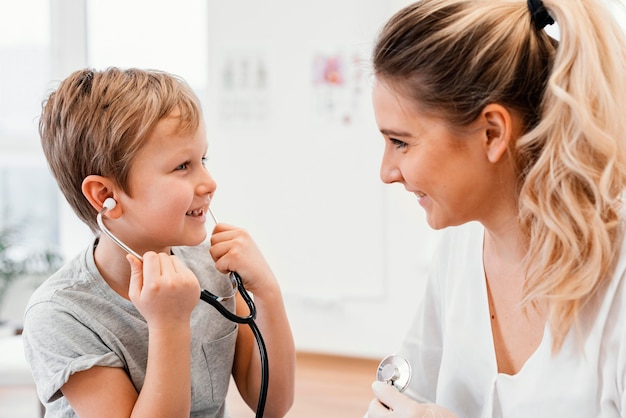 Pediatra sorridente de close-up e criança