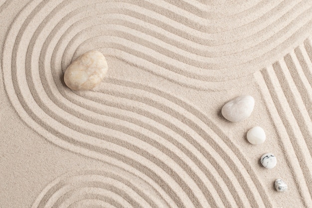 Pedras de mármore zen e fundo de areia no conceito de paz