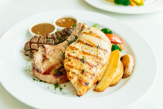 Peito de frango e costeleta de porco com bife de carne e vegetais