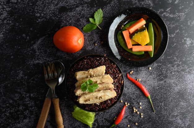 Peito de frango grelhado coberto com pimenta em bagas maduras de arroz roxo.