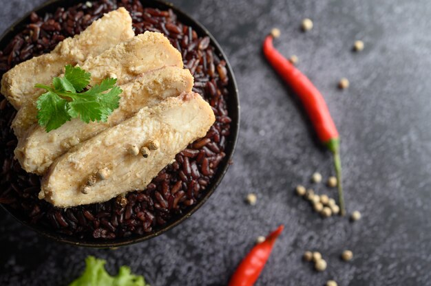 Peito de frango grelhado coberto com pimenta em bagas maduras de arroz roxo.