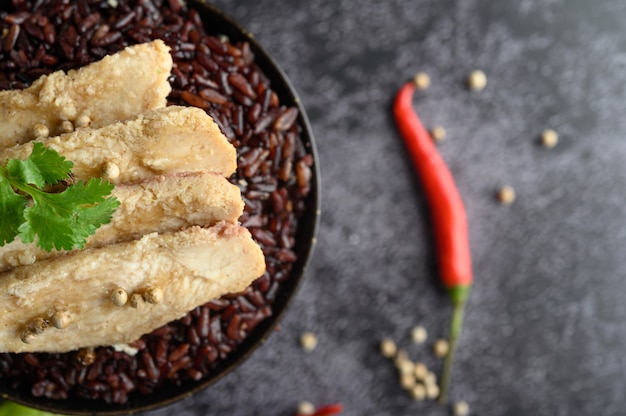 Peito de frango grelhado coberto com pimenta em bagas maduras de arroz roxo.